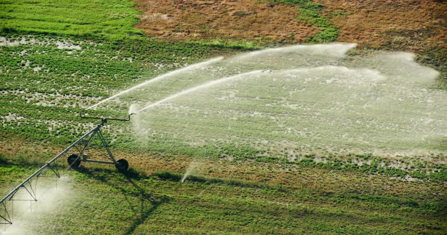 An aerial clip of a machine watering the green field