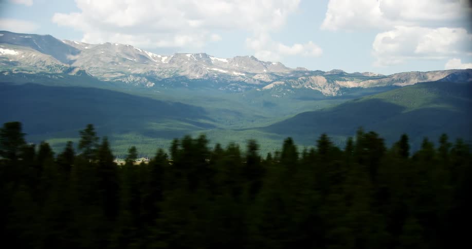 A large forest with a mountain range backdrop