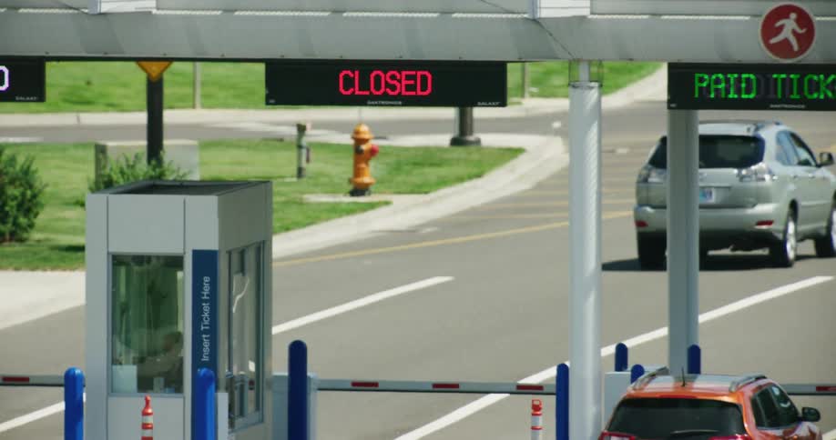 Cars doing business at a toll booth