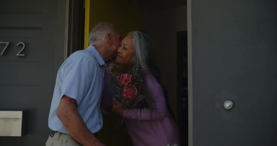 A woman greets a man who gives her flowers