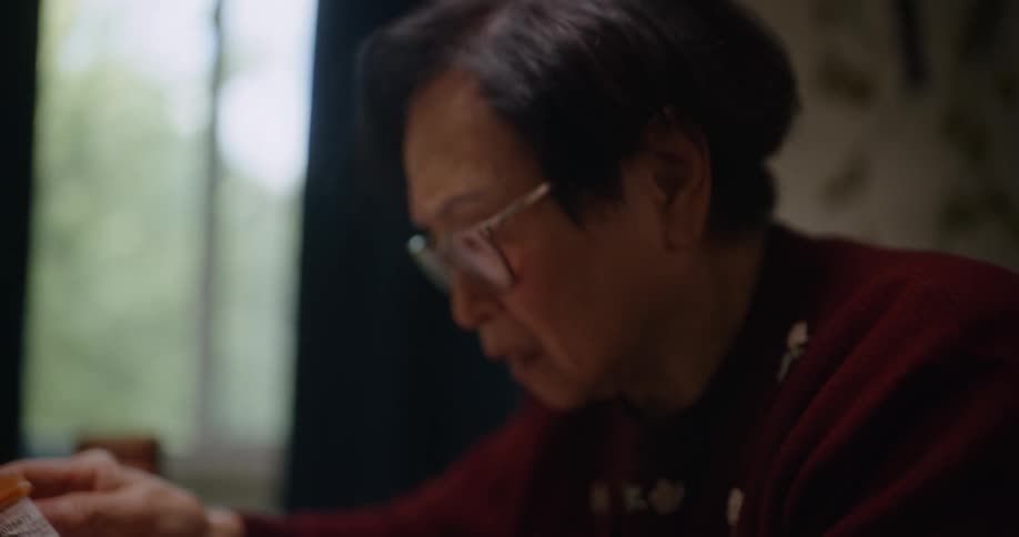 An asian woman looking worried as she looks at medication