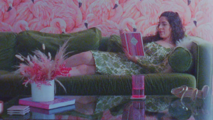 A woman lies on a couch while reading