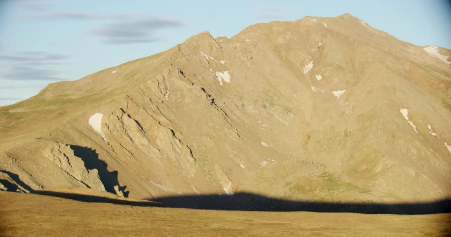 Snow dots a large mountain