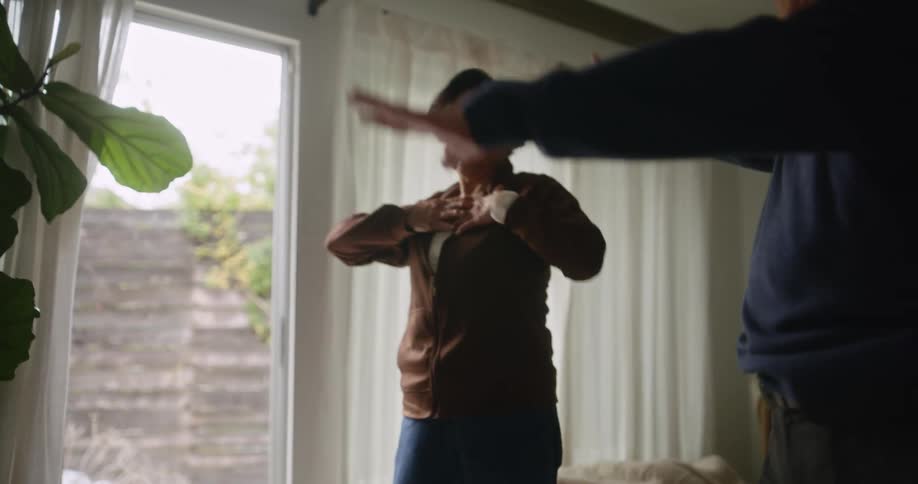 An older asian couple performs stretching exercises in their living room