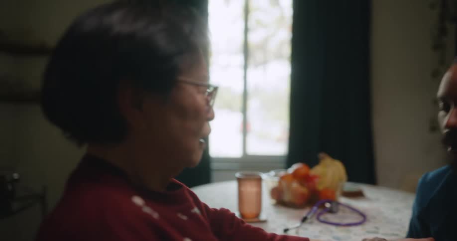 A personal care worker takes a womans blood pressure