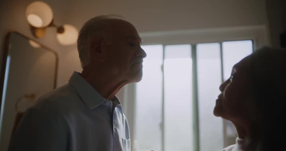 Woman passing her hand over her face and her husband then puts on prescription glasses