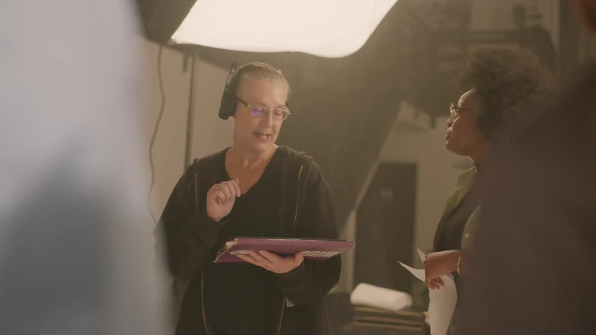 Two women talking while in a working environment with studio lighting