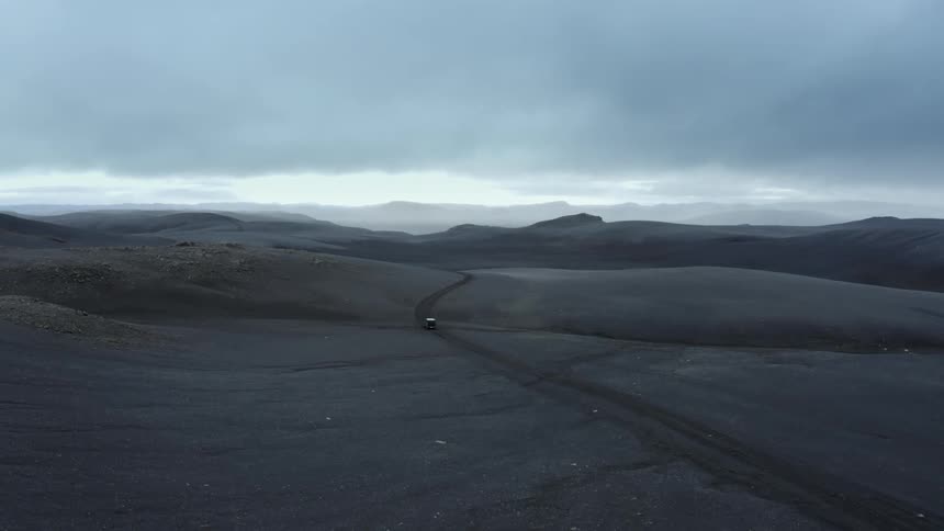 Car is driving on an empty road through the desert