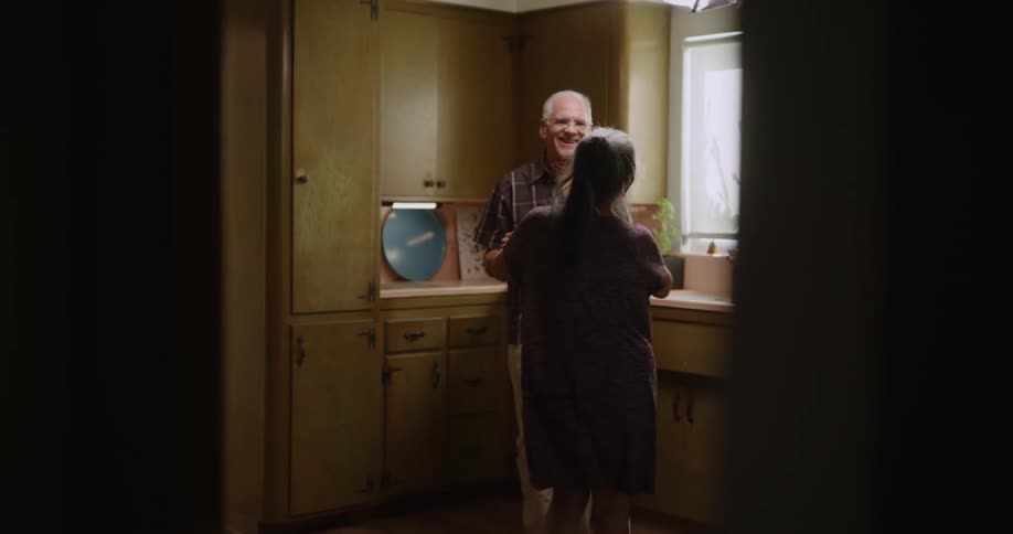 Elderly couple dancing in the kitchen romantically