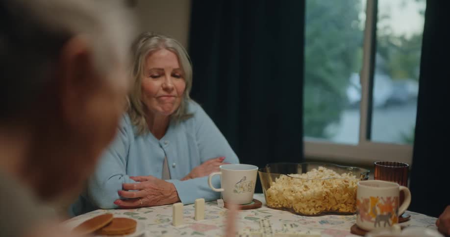 Friends sitting at a table playing dominoes