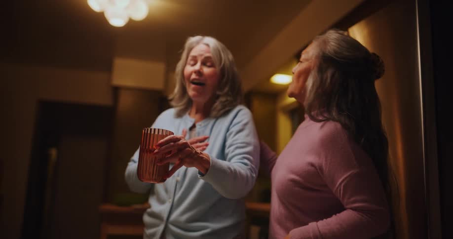 Two friends have fun picking up dishes from the table