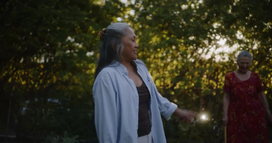Elderly ladies in the backyard in a garden having fun while playing a game of tacos