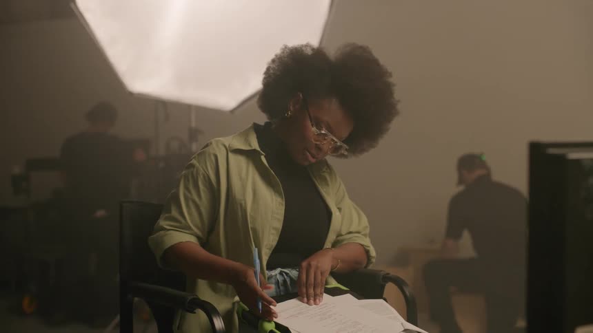 A director making notes and editing a script in the studio