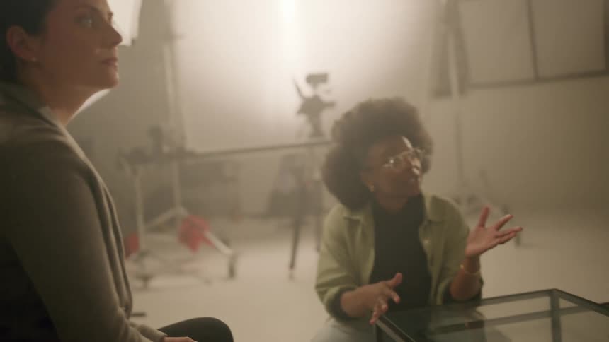 Three people talk in a studio