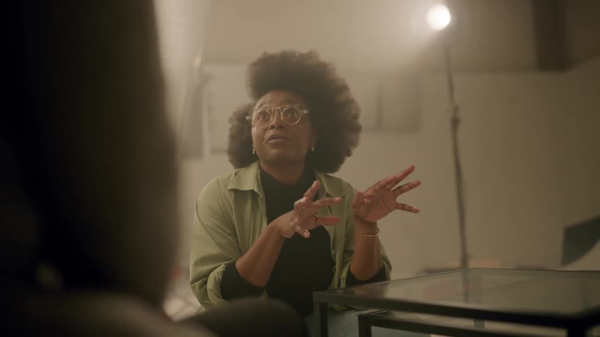 A black woman has a discussion with another person