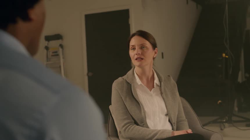 Two people sitting in a studio talking to each other