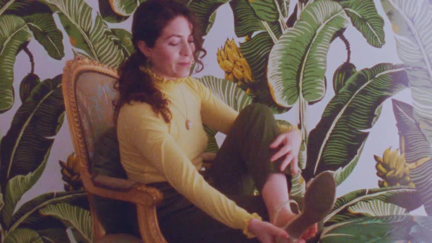 A woman taking off shoes while modeling clothes