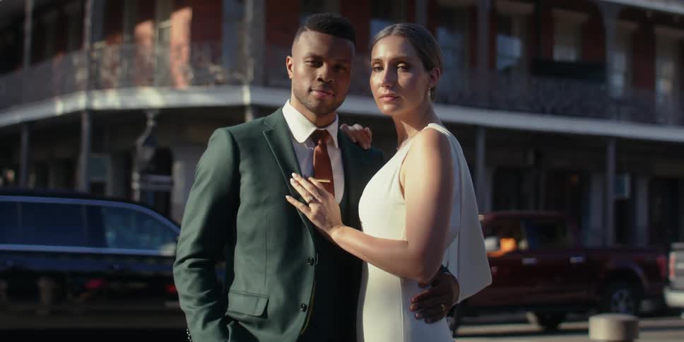 A married couple pose on the street