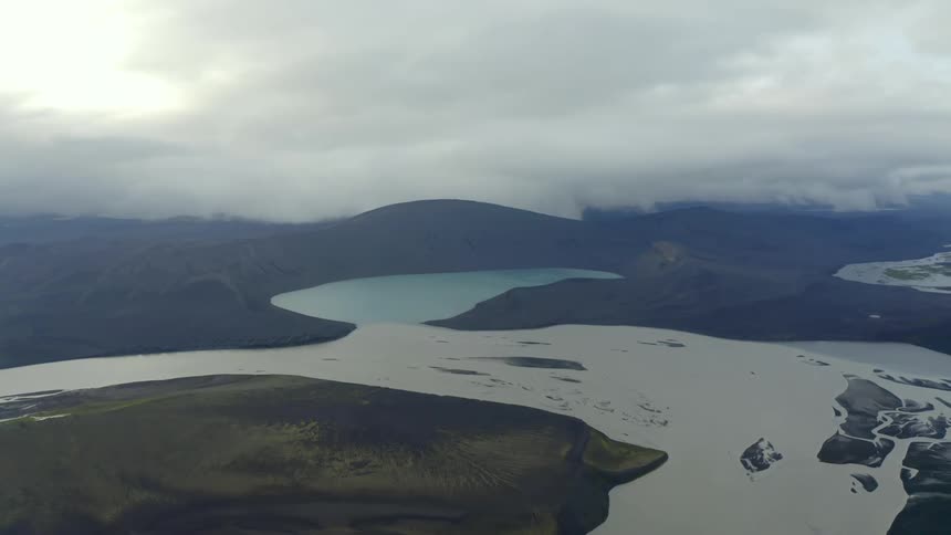 Aerial panorama of a basin surrounding mountains and hills on a cloudy winter day