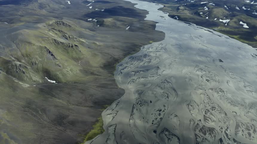 A frozen river next to mountains in early spring