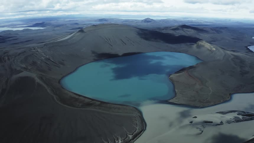Frozen lake surrounded by mountains on a cloudy day