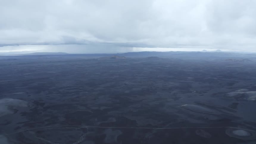 Heavy clouds float over a vast plain