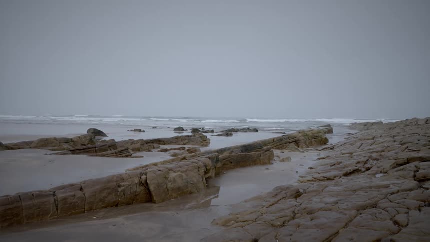 Waves roll into a rocky beach
