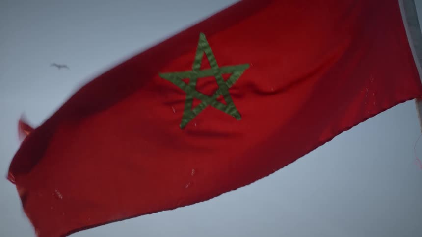 The morocco flag waving in the wind under a blue sky