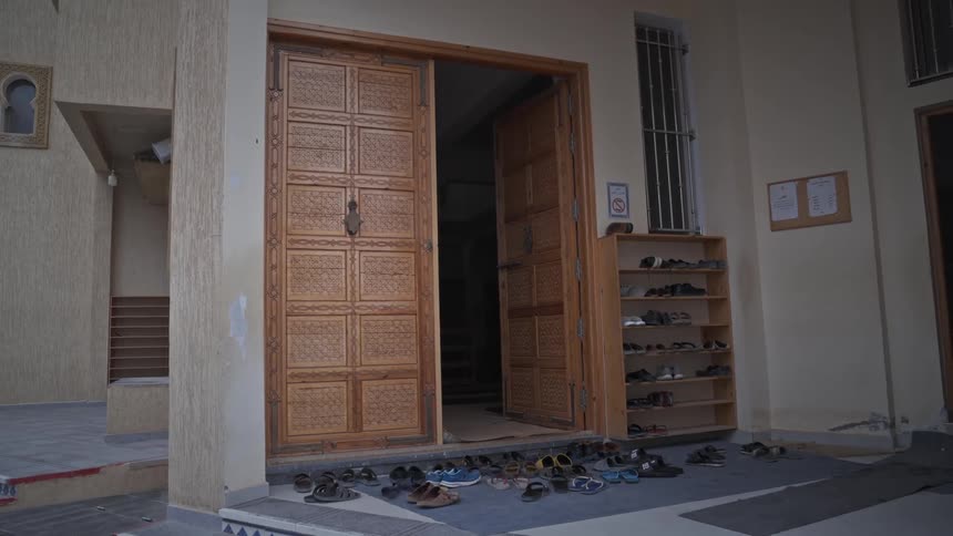 Multiple pairs of shoes are scattered on the ground in the house