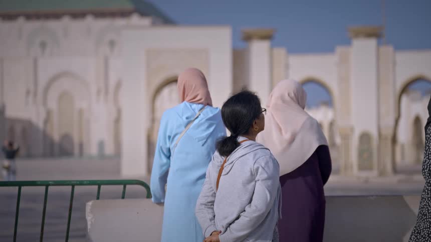 Women stand outside looking around