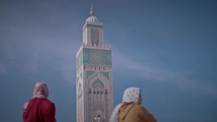 Two women looking at the tower of the hassan ii mosque