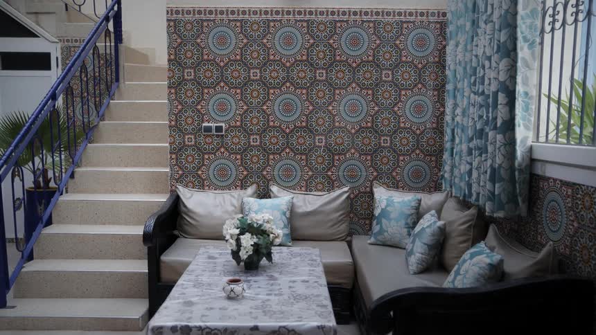 Interior architecture of a living room with sofa and artistically decorated tiled walls