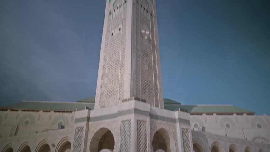 A large church building outside on a sunny day with people walking near hassan mosque