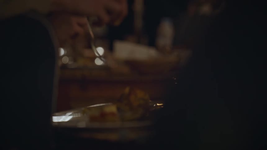 Close up of peoples hands holding cutlery and eating