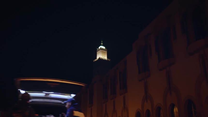 A tall church at night with bright lights coming from it