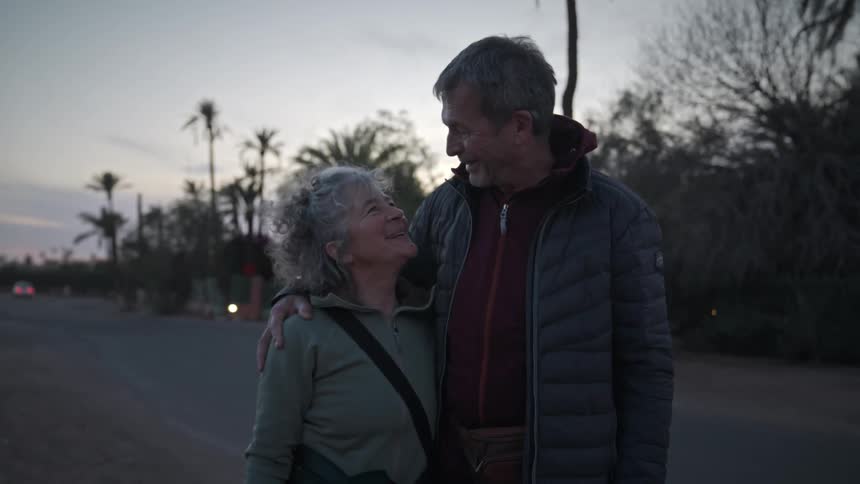 Elderly couple are hugging in a tropical scenery