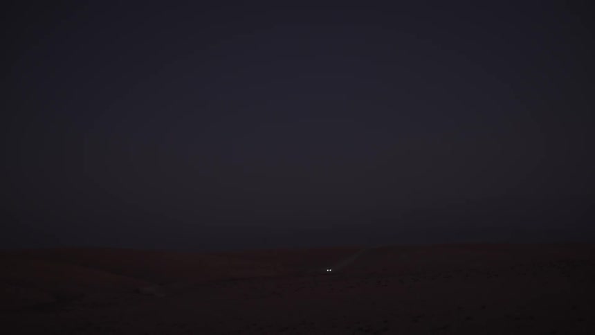 A car driving at night with his headlights on