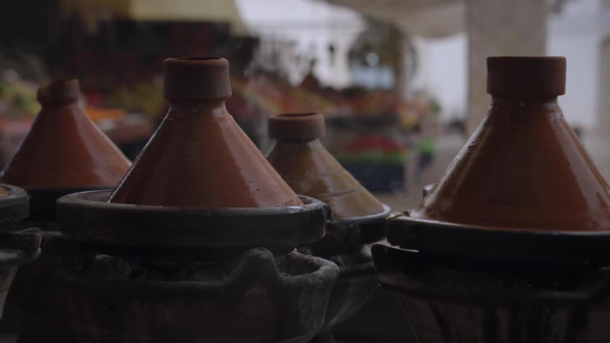 A row of steaming moroccan tagine pots on a market