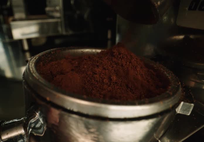 Close up of a portafilter being filled with ground coffee