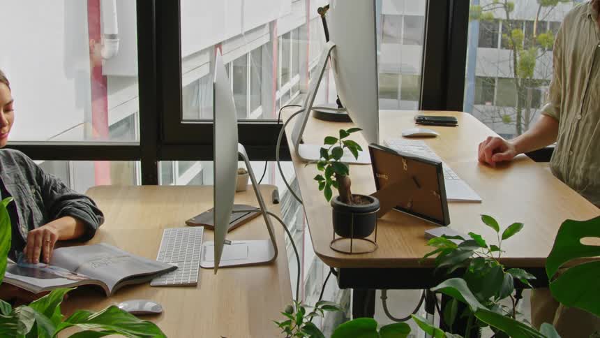 A person adjusting the height of a standing desk at the office