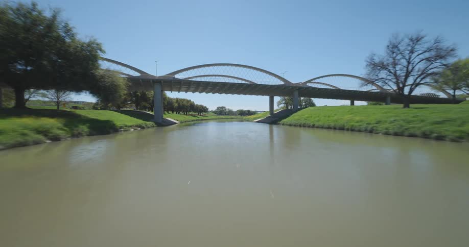 Aerial view of bridges over a river in a park under a clear sky