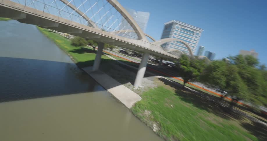 Cars are driving on a bridge over a river in the city