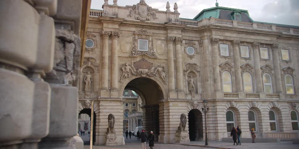 Pedestrians walk through Budapest Castle Courtyard Gate Hungary