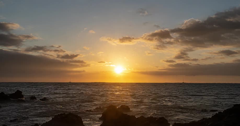 The sun is setting on the ocean