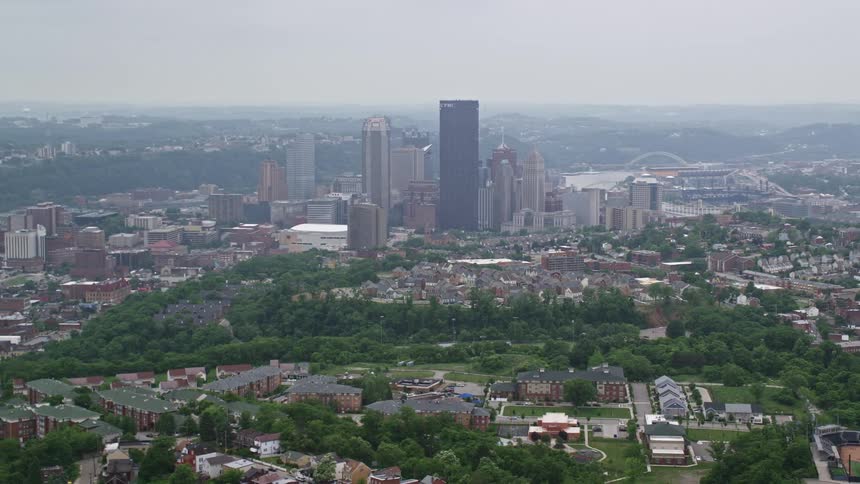 Aerial scenery of a metropolis with residential neighborhoods and skyscrapers and the silhouette of mountains on the horizon