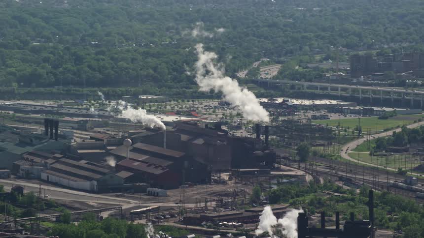 An aerial view of an industrial area with large factory buildings and smokestacks
