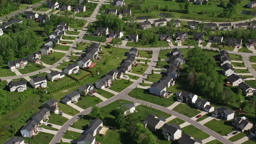 Traffic drives along streets through residential neighborhood