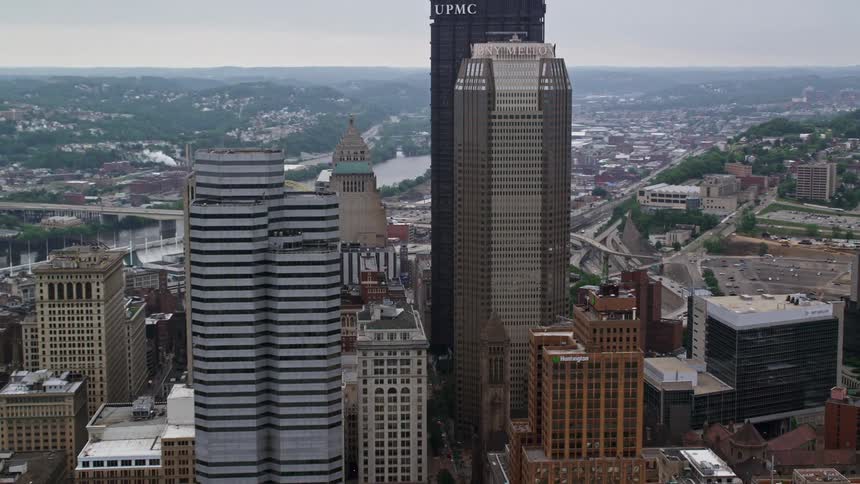 Aerial panorama of skyscrapers in a metropolis with river channels and hill vegetation around