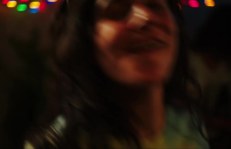 Two young women dance and laugh with one of them wearing heartshaped sunglasses
