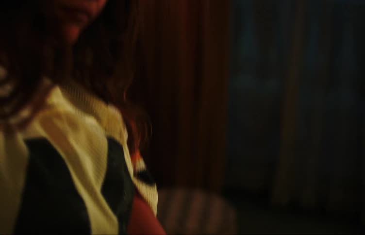 Two young women slow dance together in room at night